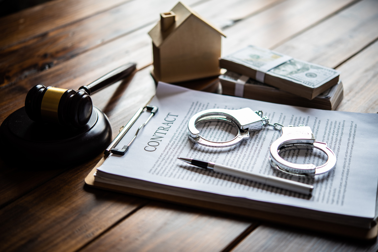 Contract, Gavel, Pen, Handcuffs and Bundles of Cash